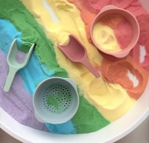 a bowl of colored sand with a spoon and spoon
