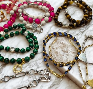 a bunch of bracelets with a variety of beads and charms