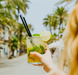 Cóctel mojito refrescant a la terrassa de Santa Lola Badalona amb palmeres de fons.