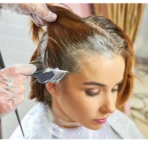 a woman is getting her hair cut by a hairdressucker