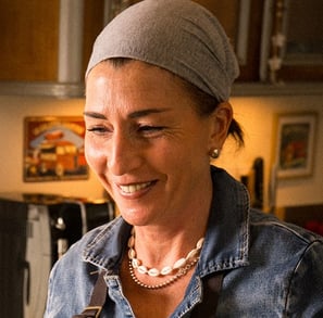 a woman in a denim jacket and pearls
