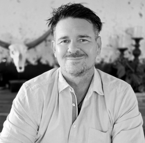 Photo of Mike in black and white sitting at a table