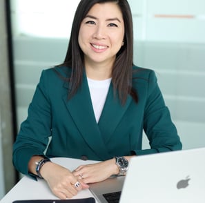 a woman in a green jacket and a laptop