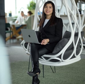 a woman sitting in a chair with a laptop on her lap
