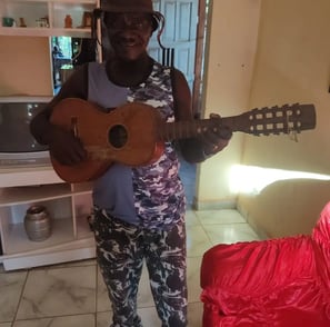 Sr. João Reis com seu violão, figura marcante da cultura quilombola de São Tomé