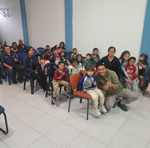a man sitting in a chair with a group of children