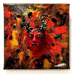Un visage sculptée rouge avec des cornes dont une cassée