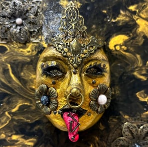 a gold mask with a face made out of gold leaf