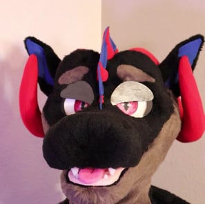 A dragon head made by Teto Creations featuring large curly horns, expressive moving eyelids and silicone teeth
