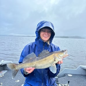 In Sweden, a female angler poses with her rainy day catch, a zander fish.