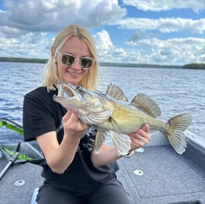 In Sweden, a female angler poses with a zander fish.