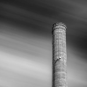 Prominent Georgetown Tx smokestack stands against a streaked cloud sky