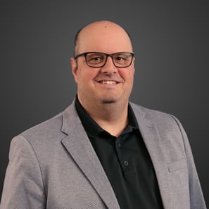a man in a suit and glasses smiling