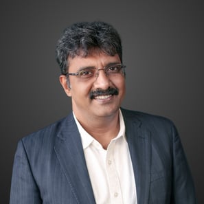 a man in a suit and glasses smiling
