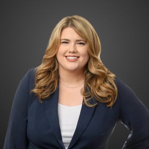 a blond woman in a blue jacket and white top