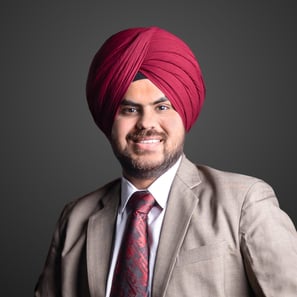 a man in a burgundy turban wearing a beige suit
