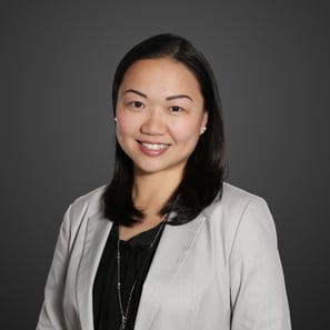 a woman in a gray jacket and black top