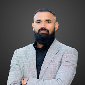 a man with a beard and grey suit