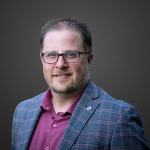 a man in a suit and glasses smiling