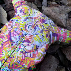 peinture aux couleurs vives sur un crane sur un lit de feuilles mortes