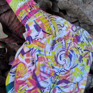 peinture aux couleurs vives sur un crane sur un lit de feuilles mortes
