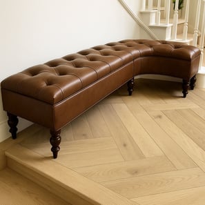 Curved tufted leather bench with turned legs, custom-built by Solo Home Decor to fit a stair landing.