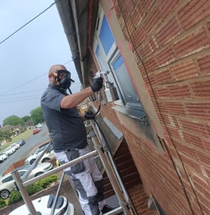 UPVC window spraying in progress on upper floor of Worcester home using scaffold tower