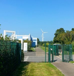 a gated in area with a fenced in area with a wind turbine