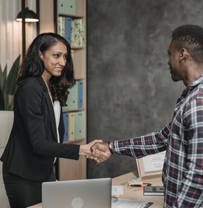 a man and woman shaking hands in a meeting room