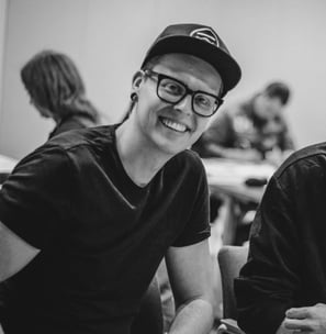 a man in a black shirt and glasses smiling