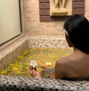 a woman in a bathtub with a flower in her hair