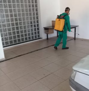 a man in green scrubsuit carrying a yellow suitcase