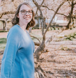 a woman in glasses and a blue sweater