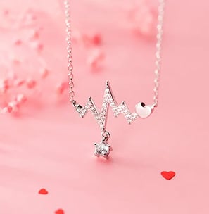 a necklace with a heart shaped pendant and a small white diamond