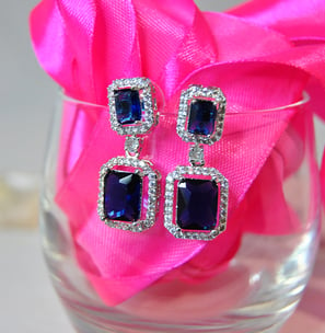 a pair of earrings with blue sapphires and diamonds