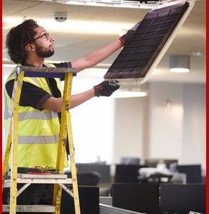 Técnico realizando mantenimiento de aire acondicionado en oficina de Valencia