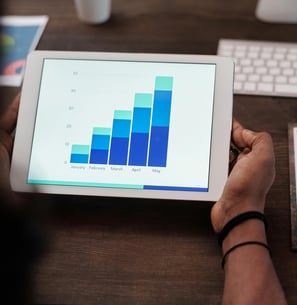 uma pessoa análisando um gráfico de desmpenho de seu cliente de marketing digital