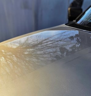 A truck hood showing polishing paint correction results