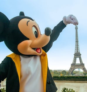 Mickey Mouse standing beside the Eiffel Tower near Disneyland Paris
