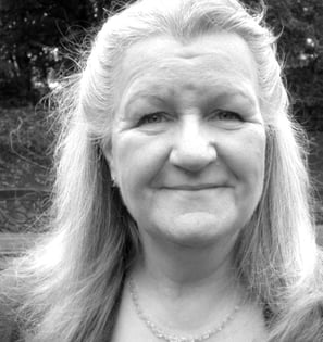 A black and white headshot of a woman in her 60s.