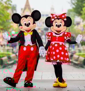 Mickey and Minnie Mouse standing holding hands at Walt Disney World in Florida