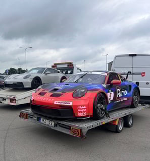 an Enlab Porsche race car being towed by a trailer