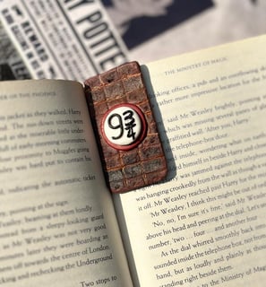 brick wall textured bookmark with platform 9 3/4 sign on the center displayed on a harry potter book