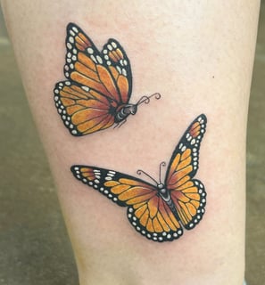 a butterfly tattoo on the leg of a woman's leg