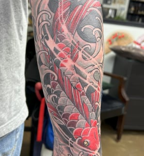 a tattoo on the arm of a man's arm koi fish color tattoo