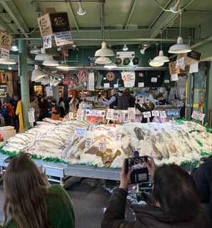 Pike Place Fish market, with a large open cooler full of ice and whole fish