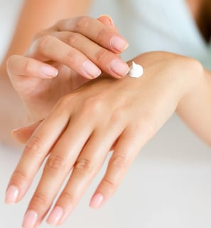 a woman's hands holding a habu secrets cream tube