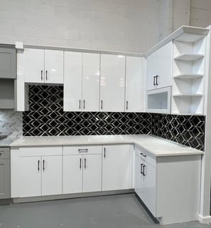 a kitchen with white cabinets and black and white cabinets