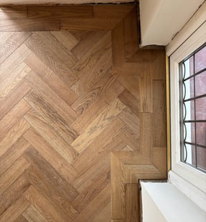 A brown oak herringbone floor with a double border