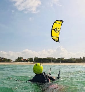 pessoa controlando o kitesurf dentro da água.